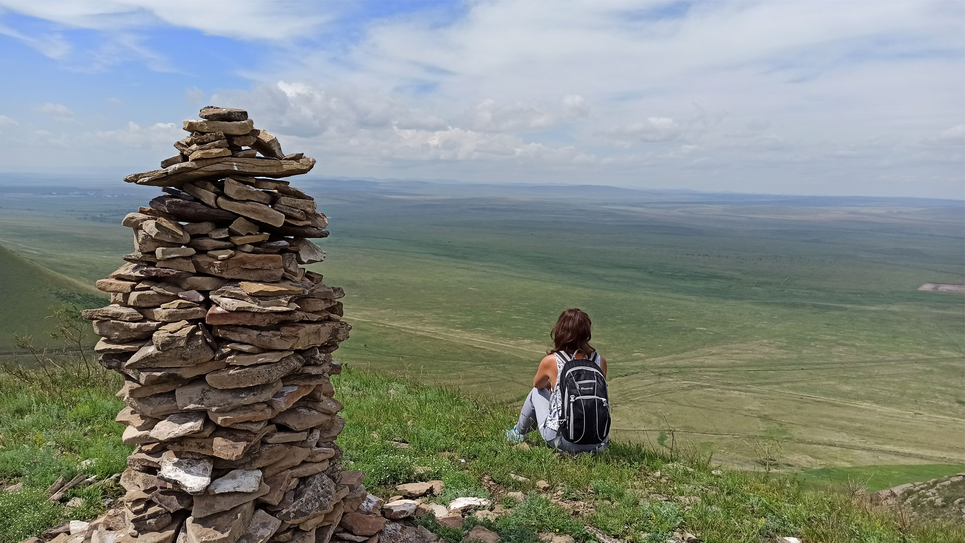 Девушка сидит на вершине Куни, панорама в сторону Пригорска.